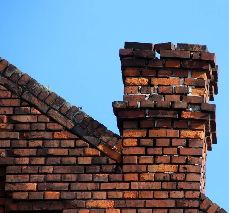 Damaged chimney on an Brockton home showing cracks and missing mortar